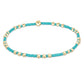 Turquoise and gold beaded bracelet on a white background