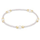 Bracelet with white beads and gold accents on a white background